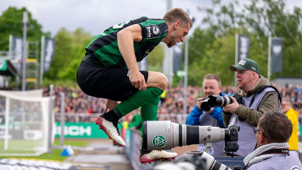 Marc Lorenz springt zum Feiern nach seinem frühen Führungstreffer über die Bande im Preußenstadion.