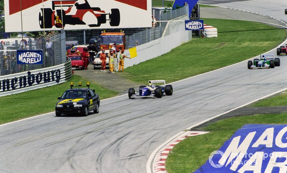 The Safety Car leads Ayrton Senna, Williams FW16 Renault, and Michael Schumacher, Benetton B194 Ford.