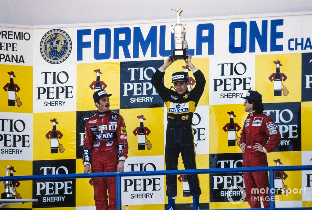 Ayrton Senna celebrates victory on the podium with Nigel Mansell, 2nd position, and Alain Prost, 3rd position.